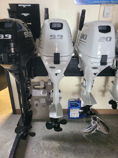 Suzuki outboard motors on display, various sizes